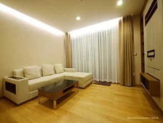 Modern living room with light-colored furniture and floor-to-ceiling windows