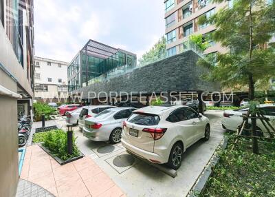 Outdoor parking area with multiple cars and surrounding buildings