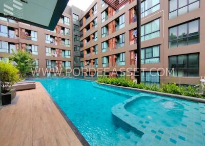 Outdoor pool area with modern apartment building