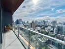 View of city skyline from balcony with glass railing