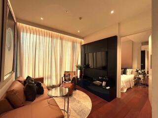 Modern living room with large window, brown sofa, circular coffee table, TV, and access to bedroom