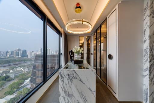 Modern corridor with large windows offering city view, marble island, and modern lighting