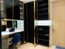 Modern home study area with built-in black and gold shelves, wooden door, and workspace