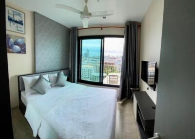 Bedroom with large bed, ceiling fan, and city view