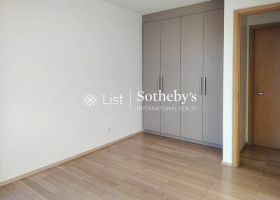 Spacious bedroom with wooden flooring and built-in wardrobes