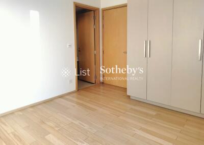 Spacious bedroom with wooden flooring and built-in wardrobe