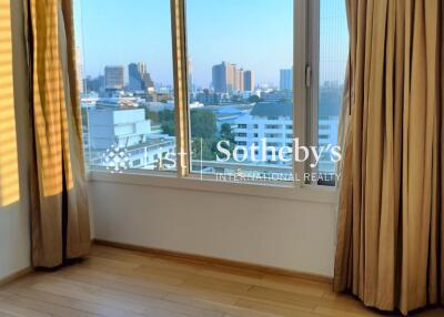 Bright bedroom with large window and city view