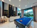 Modern living room with pool table and large windows