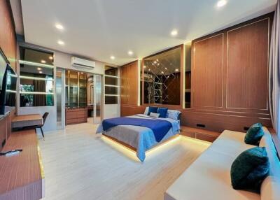 Spacious modern bedroom with large bed, seating area, and built-in storage