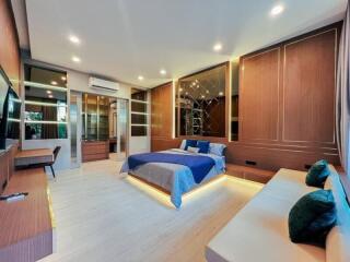 Spacious modern bedroom with large bed, seating area, and built-in storage