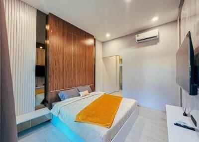 Spacious modern bedroom with wooden accent wall and mounted air conditioner