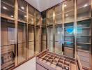 Spacious walk-in closet with glass-paneled doors and built-in shelving