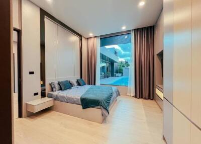 Modern bedroom with large window and pool view