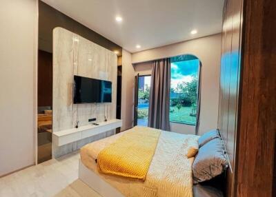 Modern bedroom with large window and mounted TV