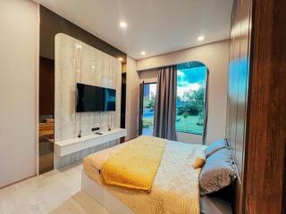 Modern bedroom with large window and mounted TV