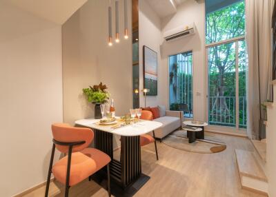 Modern living and dining area with high ceiling and natural light