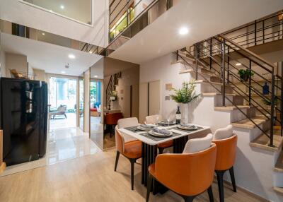 Modern dining area with table set for four and staircase