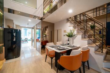 Modern dining area with table set for four and staircase