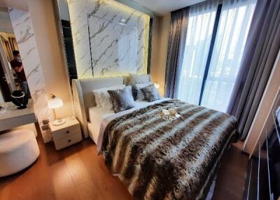 Modern bedroom with large bed, bedside lamps, and full-height windows