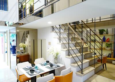 Modern dining area with a staircase and open balcony