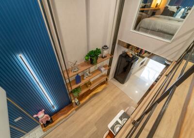 Contemporary multi-level living area with shelving and view into bedroom