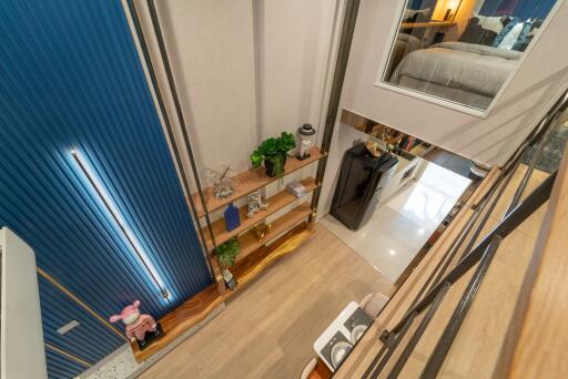 Contemporary multi-level living area with shelving and view into bedroom