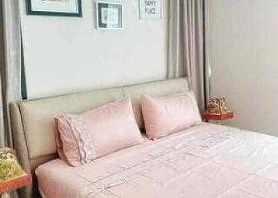 Comfortable bedroom with pink bedding and framed pictures on the wall