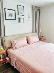 Comfortable bedroom with pink bedding and framed pictures on the wall