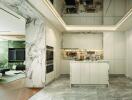 Modern kitchen with marble accent and adjacent living room