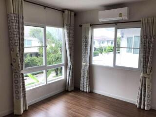 Bright bedroom with large windows and air conditioning