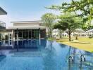 modern outdoor swimming pool with trees and building