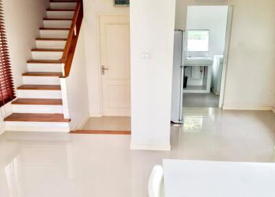 Main living area with stairs and view into kitchen