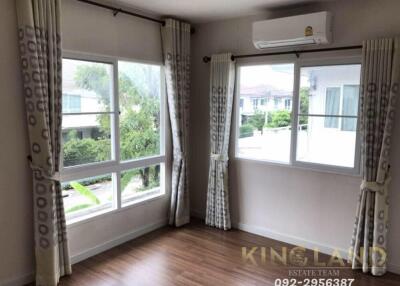 A bedroom with large windows and wooden floors