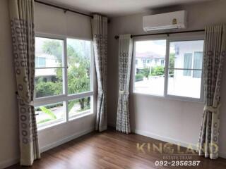 A bedroom with large windows and wooden floors