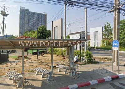 View of a bus stop shelter with a residential or commercial building in the background