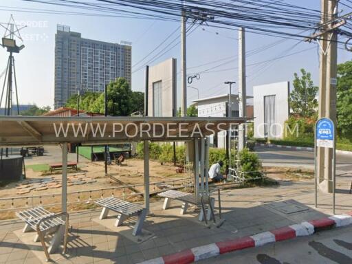 View of a bus stop shelter with a residential or commercial building in the background