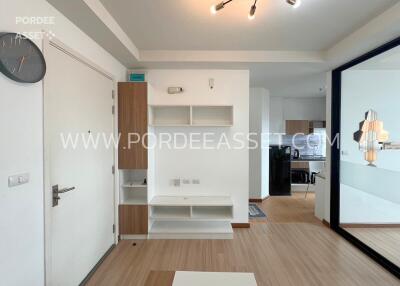 Main living area with white shelves and mirror