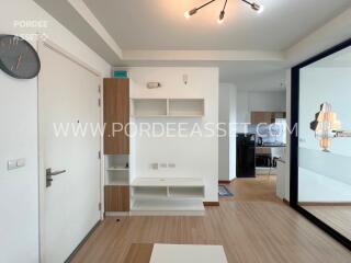 Main living area with white shelves and mirror