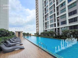 Outdoor swimming pool area with lounge chairs at residential building