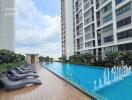 Outdoor swimming pool area with lounge chairs at residential building