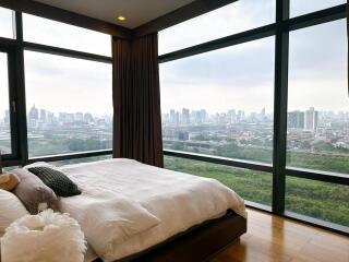 Bedroom with large windows and city view