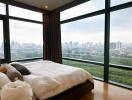 Bedroom with large windows and city view