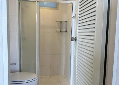 Bathroom with a shower, toilet, and tiled floor.