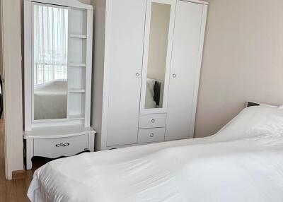 Bedroom with white furniture and a neatly made bed