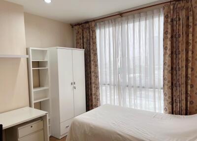 bedroom with white wardrobe and large window