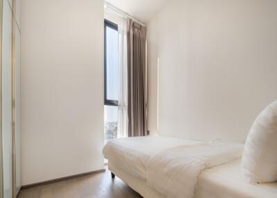 Bright bedroom with large window and white bedding