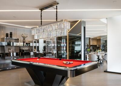 Modern entertainment room with a pool table and elegant chandelier