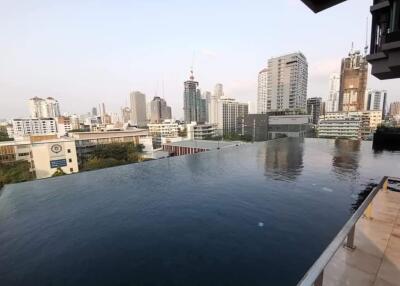 View of an infinity pool with a cityscape backdrop