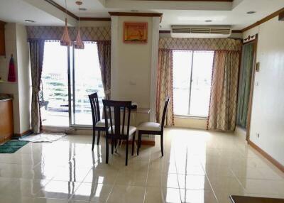 Bright dining area with table and chairs, large windows, and balcony access