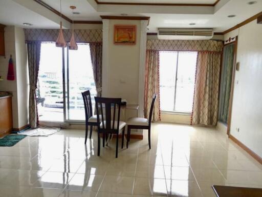 Bright dining area with table and chairs, large windows, and balcony access